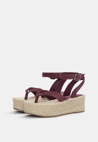 Maroon mockasinsandaler med kilklack som har en flätad jute-sula, ankle straps och spänne. Platt, strukturerad fotsula för komfort.