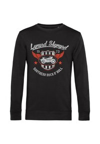 Černá dlouhá košile s grafickým designem obsahujícím "Lynyrd Skynyrd," motocyklem a červenými křídly na kulaté nášivce.