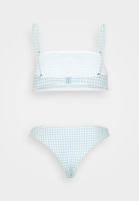 Conjunto de bikini de padrão xadrez azul, apresentando um top de bralette estruturado com alças ajustáveis e uma parte inferior de cintura baixa correspondente. Textura de tecido suave.