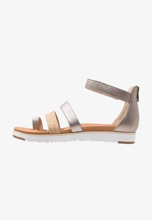 Płaskie sandały z metallicznymi skórzanymi paskami, korkowym akcentem, paskiem na kostkę z zamkiem oraz wyściełanym brązowym wkładem na białej podeszwie.