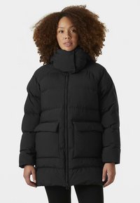 Juoda pūkinė striukė su aukštu apykakle, turi dvi priekinės kišenes, užtrauktuką ir siūlėtą dizainą su lygiu paviršiumi.