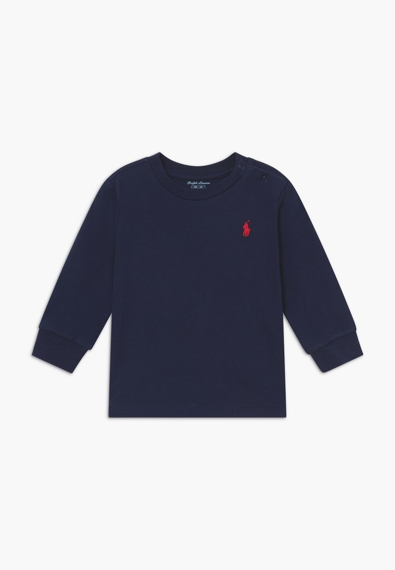 Mörkblå långärmad tröja för småbarn i bomullsmaterial, med rund halsringning, ribbstickade muddarna och en liten röd broderad logotyp. Tryckknapp på axeln.