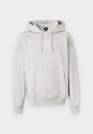 Sivá mikina s kapucňou s prednou kapsou a bielym logom 'GAP'. Mäkko tkanina s rebrovanými manžetami a lemom. Neformálny dizajn s šnúrkami.