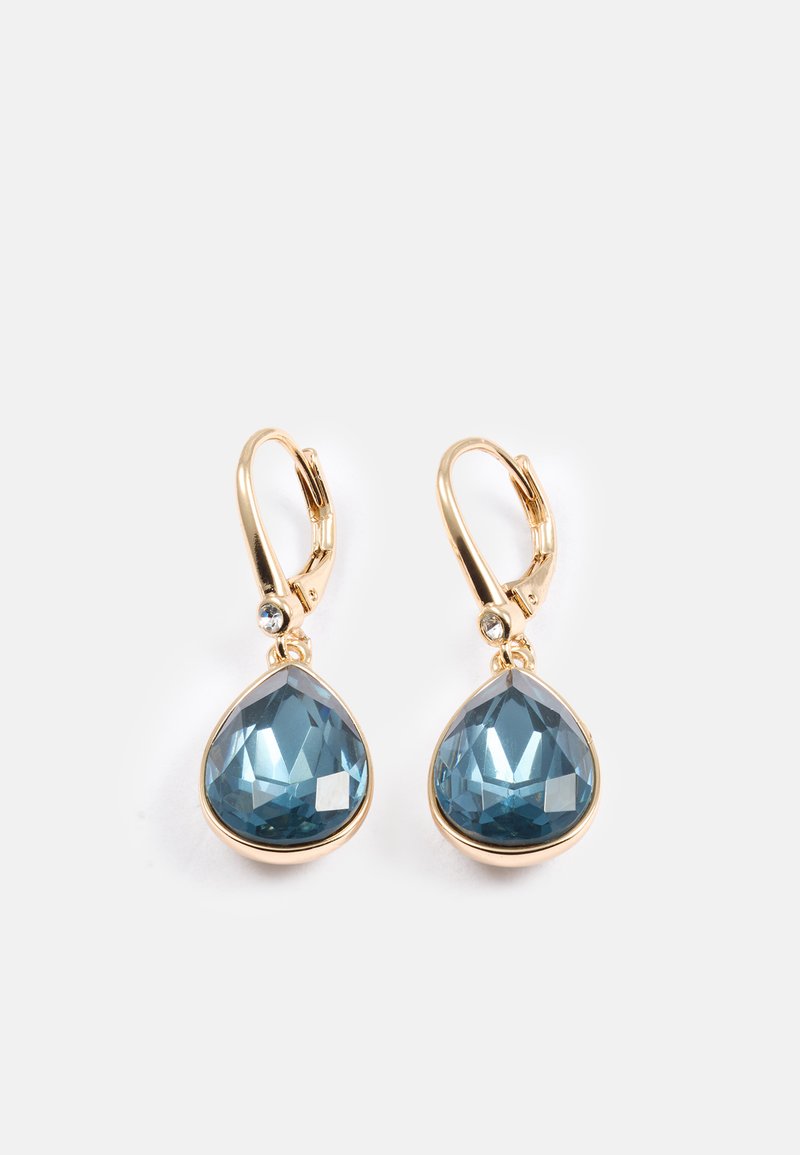 Guldtonade droppformade örhängen med blå fasetterade kristaller och klara stenar som accent. Slät yta med en spänne i form av en leverbak.