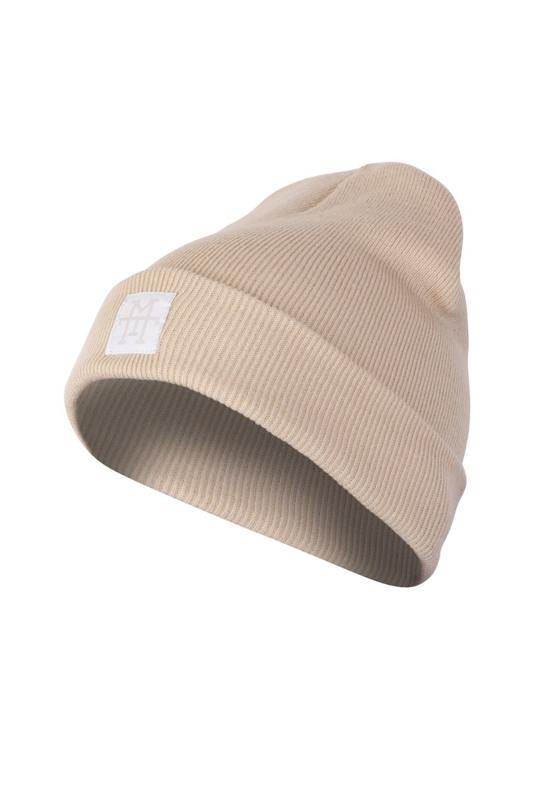 Knit beanie in light beige with a ribbed texture. Features a folded cuff and a small white logo patch on the side.