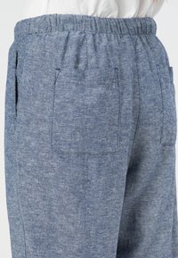 Blå bukser i en linnedblend med elastisk talje, to sidelommer og en tekstureret overflade. Tøjet har en afslappet pasform og et uformelt design.