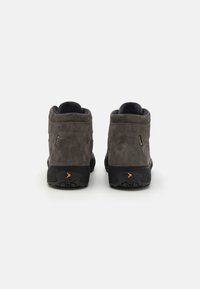 Graue Wildleder-Stiefeletten mit schwarzen Gummisohlen, die eine auffällige orange Akzentuierung an der Ferse und ein strukturiertes Obermaterial für besseren Halt bieten.