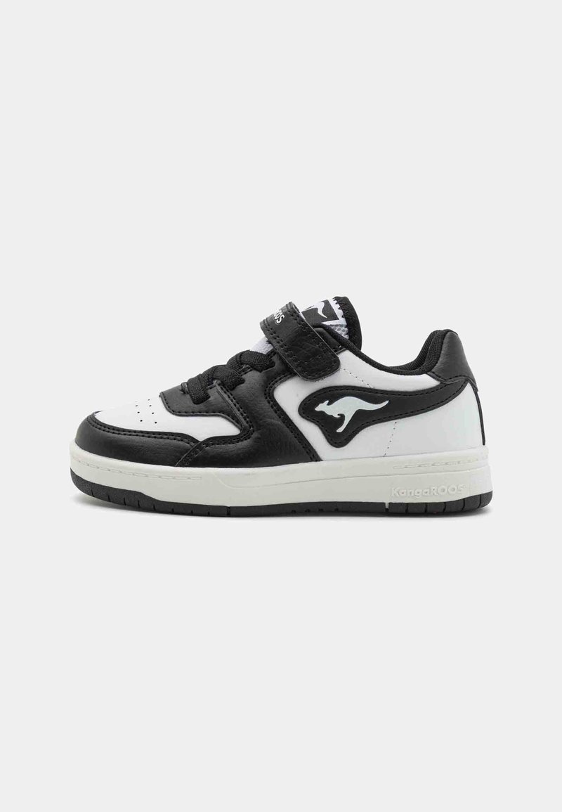 Svart og hvit sneakers laget av lær. Har borrelåsrem, teksturerte detaljer og gummisåle. Kenguru-logo på siden.