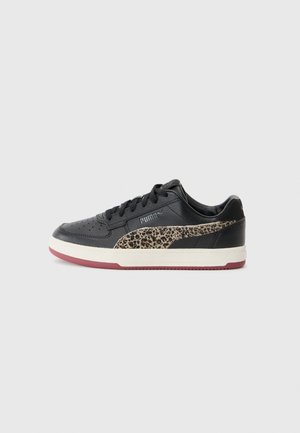 Sort Puma sneaker med leopardprintstribe, hvid sål, rød ydersål og sorte snørebånd på en lys grå baggrund.