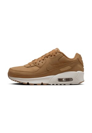 Zapatilla de deporte de cuero sintético color marrón con diseño de cordones, suela media blanca, amortiguación de aire visible y suela texturizada para tracción.