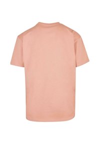 Helles rosa T-Shirt mit kurzen Ärmeln, rundem Halsausschnitt und nahtlosen Schultern. Glattes Baumwollmaterial mit einem leicht lockeren Schnitt.