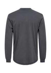 Langarmshirt in donkergrijs, gemaakt van zacht materiaal. Heeft een ronde halslijn en een afgeronde zoom met zijslitten voor comfort.