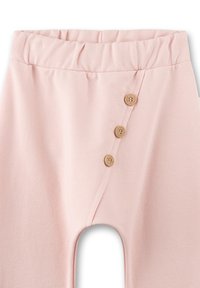 Weiche rosa Babyhose mit elastischem Bund und drei vertikalen Holzknöpfen an der linken Vorderseite.