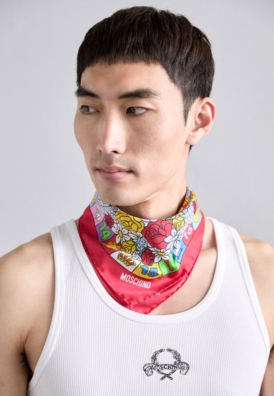 Rød silkescarf med blomster mønstre og tal i livlige farver, båret om halsen. Har et logo i et hjørne. Glat tekstur.