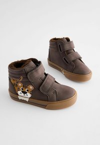 Bruna högstövlade skor med dubbla Velcro-remmar, med en tigerdesign på ena sidan och brunt konstfärgat foder inuti. Gummisula.