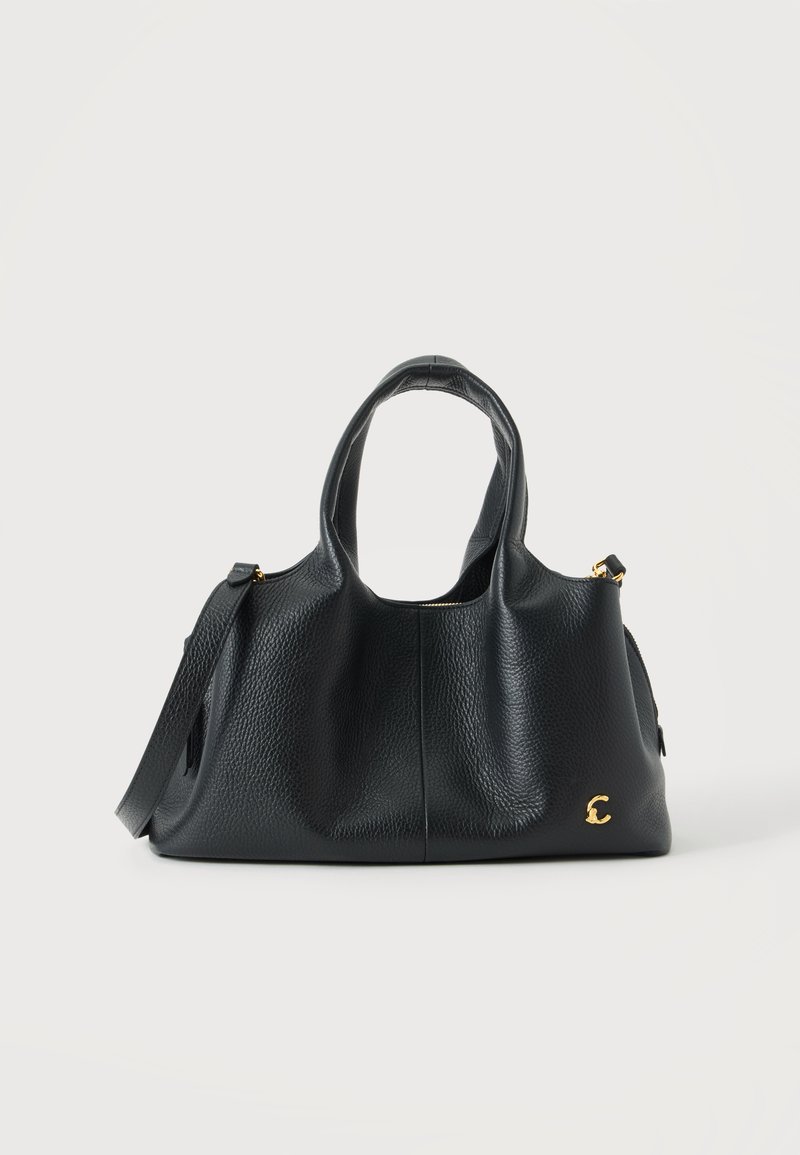 Sac à main en cuir noir texturé avec double poignée, bandoulière amovible et petit logo doré sur le devant, sur un fond clair uni.