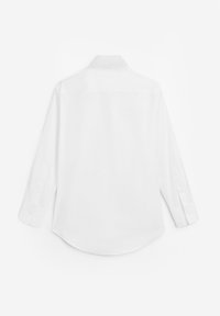 Chemise blanche à manches longues boutonnée, vue de dos avec un col standard et des poignets boutonnés sur un fond uni.