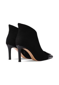 Stivali alla caviglia neri in suede con punta affusolata e cappuccio in pelle liscia. Presentano una silhouette elegante e un tacco alto e sottile.