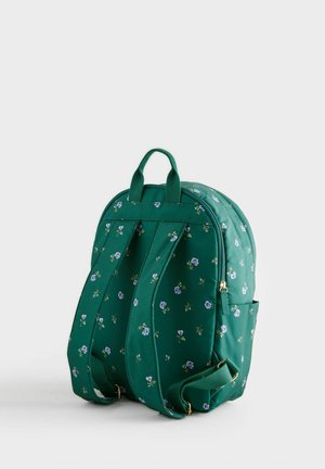 Zaino di tessuto verde con motivo floreale, dotato di due spallacci, una maniglia superiore e dettagli in oro.