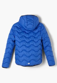 Blå quiltet pufferjakke med hætte, der har bølgemønster, polstret struktur, elastiske manchetter og et lille logo nederst.