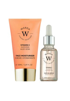 Pomarańczowa tubka z witaminą C kremu nawilżającego do twarzy z gliceryną i aloesem, obok przezroczystej buteleczki z pipetą z olejkiem-serum do twarzy z witaminą C z olejem migdałowym.