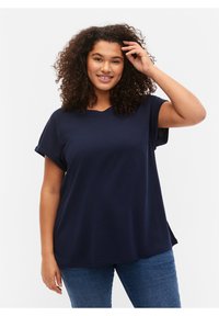 Marinblå kortärmad t-shirt med avslappnad passform, rundad halsringning och uppvikta ärmslut. Mjuk bomullstyg med en slät yta.