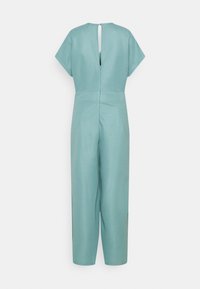 Een mintgroene jumpsuit met korte mouwen, een sleutelgatdetail op de rug en een relaxte pasvorm met rechte benen. Gemaakt van lichtgewicht stof.