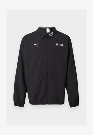 Čierna bunda na zips s logom Puma na ľavej strane hrude, logom BMW M na pravej strane hrude, elastickými manžetami a malým emblémom na golieri.