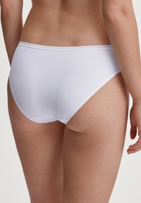 Slip in cotone bianco con una texture liscia e un design minimalista. Presenta una vita bassa e un taglio classico, che offre una copertura totale.