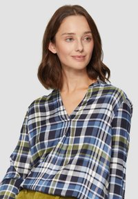 Langärmliges kariertes Hemd in Marineblau, Grün und Weiß. Verfügt über einen V-Ausschnitt mit Faltendetails und einem lockeren Schnitt. Weicher, gewebter Stoff.