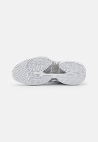 Talpa unei încălțăminte atletice albe, cu model herringbone și hexagonal, având o textură netedă și accente transparente.
