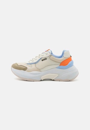 Masywny beżowy sneaker z siateczkowymi bokami, jasnoniebieskimi i pomarańczowymi akcentami, grubą białą podeszwą oraz logo "BOSS" na zewnętrznej stronie.