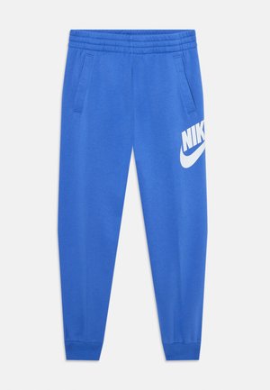 Zili zili sporta bikses, kas izgatavotas no mīkstas auduma, ar elastīgu jostu, sānu kabatām un lielu balto Nike logo kreisajā augšstilbā.