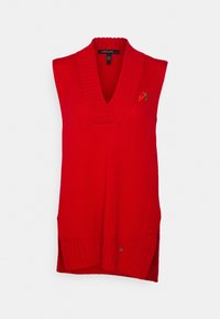 Pull sans manches rouge en tricot avec un col en V profond, texture côtelée, fentes latérales et petit détail brodé d'un piment.