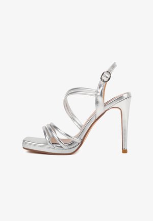 Sandali con tacco alto in argento, con cinturini incrociati, punta quadrata e cinturino alla caviglia regolabile. Finitura metallica e tacco a stiletto sottile.