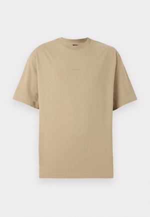 Beige katoenen t-shirt met korte mouwen, ronde hals en subtiele logo-details op de voorkant. Vlotte structuur, casual ontwerp.