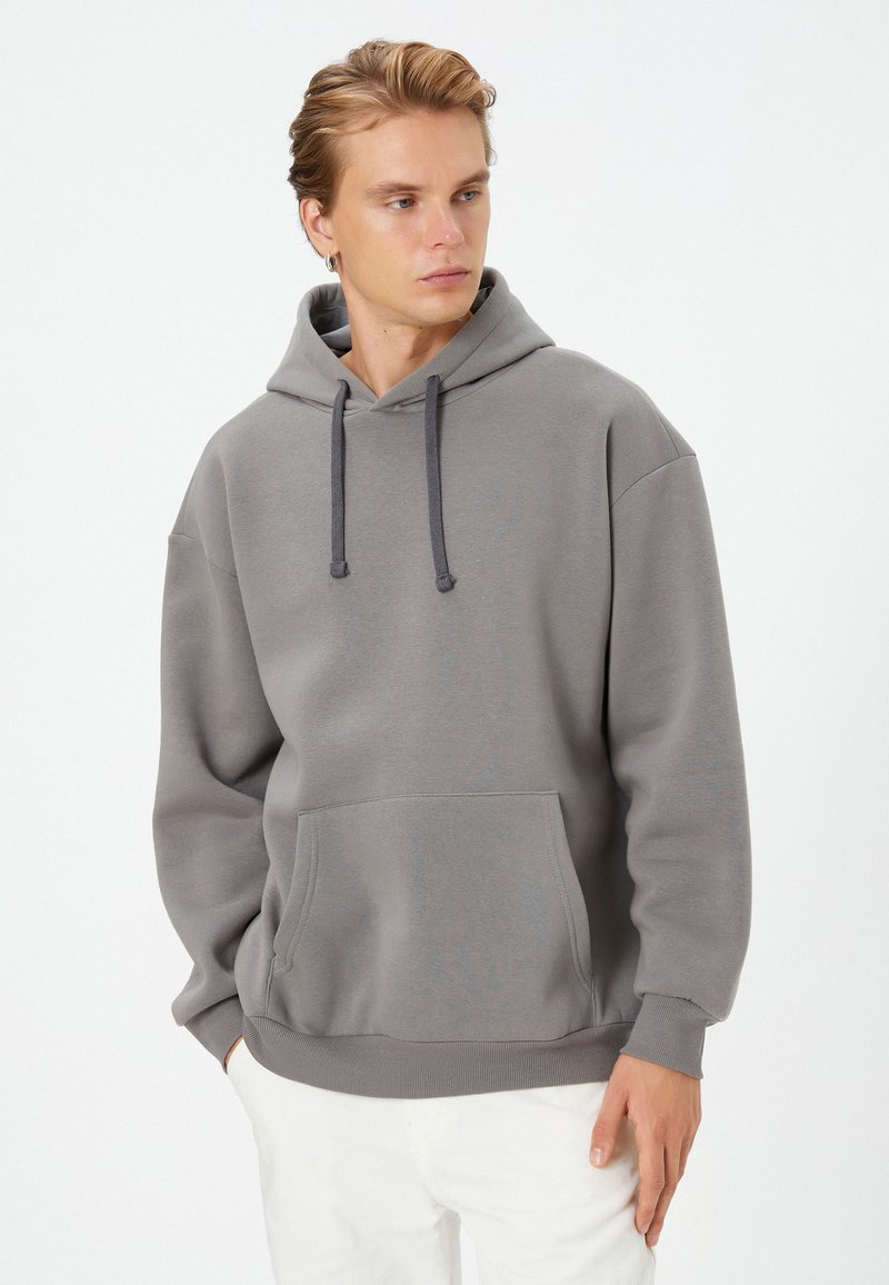 Gray pullover hoodie made of soft fabric, featuring a front kangaroo pocket, adjustable drawstring hood, and ribbed cuffs and hem.