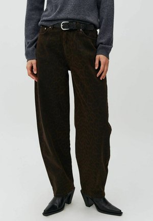 Person wearing dark brown leopard-print wide-leg pants, black belt, dark gray sweater, and black heeled ankle boots.