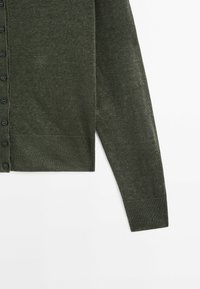 Donkergroene gebreide cardigan met een knoopsluiting aan de voorkant, geribde manchetten en zoom, en een gladde textuur. Vijf zwarte knopen zichtbaar.