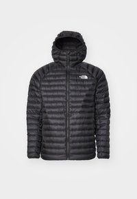 Zwarte gewatteerde jas met capuchon, voorzien van een volle rits, gequiltde textuur en logo op de linkerborst. Ontworpen voor warmte en lichtgewicht comfort.