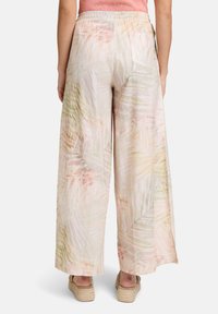 Brede broek in lichte stof met een pastel palmblaadjespatroon. Heeft een elastische tailleband en een achterzak.