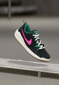 Mustad mustad, millel on rohelised detailid, roosa Nike logo, valged paelad, võrgusilma ülemine osa ja kummist põhi, millel on sujuv disain ja Jordan bränd.