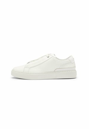 White leather sneaker featuring a textured upper, a round toe, minimalistic design, and a rubber sole with stitched detailing.