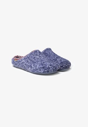 Lilla fuzzy slippers med en tekstureret overflade, åben bagside og mønstret indvendig foring. Har en fleksibel sål og en rund tådesign.