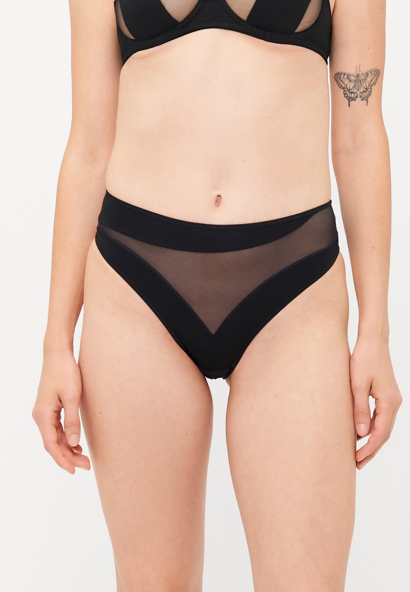 Zwarte high-waisted onderbroek met een doorzichtig gaas voorkant en een solide achterkant. Het ontwerp heeft een brede tailleband en V-vormige accenten.