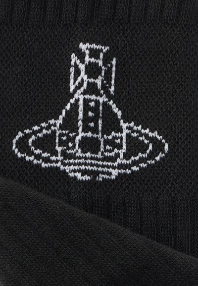 Μαύρη πλεκτή κάλτσα με λευκό κεντητό γραφικό που απεικονίζει μια δομή σαν πύραυλο μέσα σε κυκλικό σχέδιο. Μαλακή υφή, ελαστικό μανσέτα.