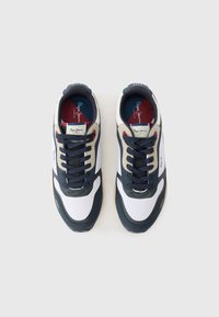 Μπλε σκούρα και λευκά αθλητικά παπούτσια με επάνω μέρος από σουέντ και δίχτυ, με μπεζ λεπτομέρειες, μαύρα κορδόνια και ετικέτα με λογότυπο στη γλώσσα. Λαστιχένια σόλα.