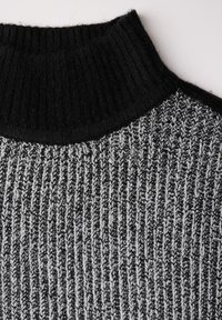 Pull en maille à col roulé en noir et gris. Présente une texture côtelée et un design de col contrastant, mettant en avant un mélange de matériaux.
