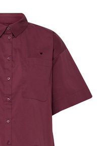 Chemise bordeaux à manches courtes avec col, poche poitrine et petit cœur brodé au-dessus de la poche sur le côté gauche.