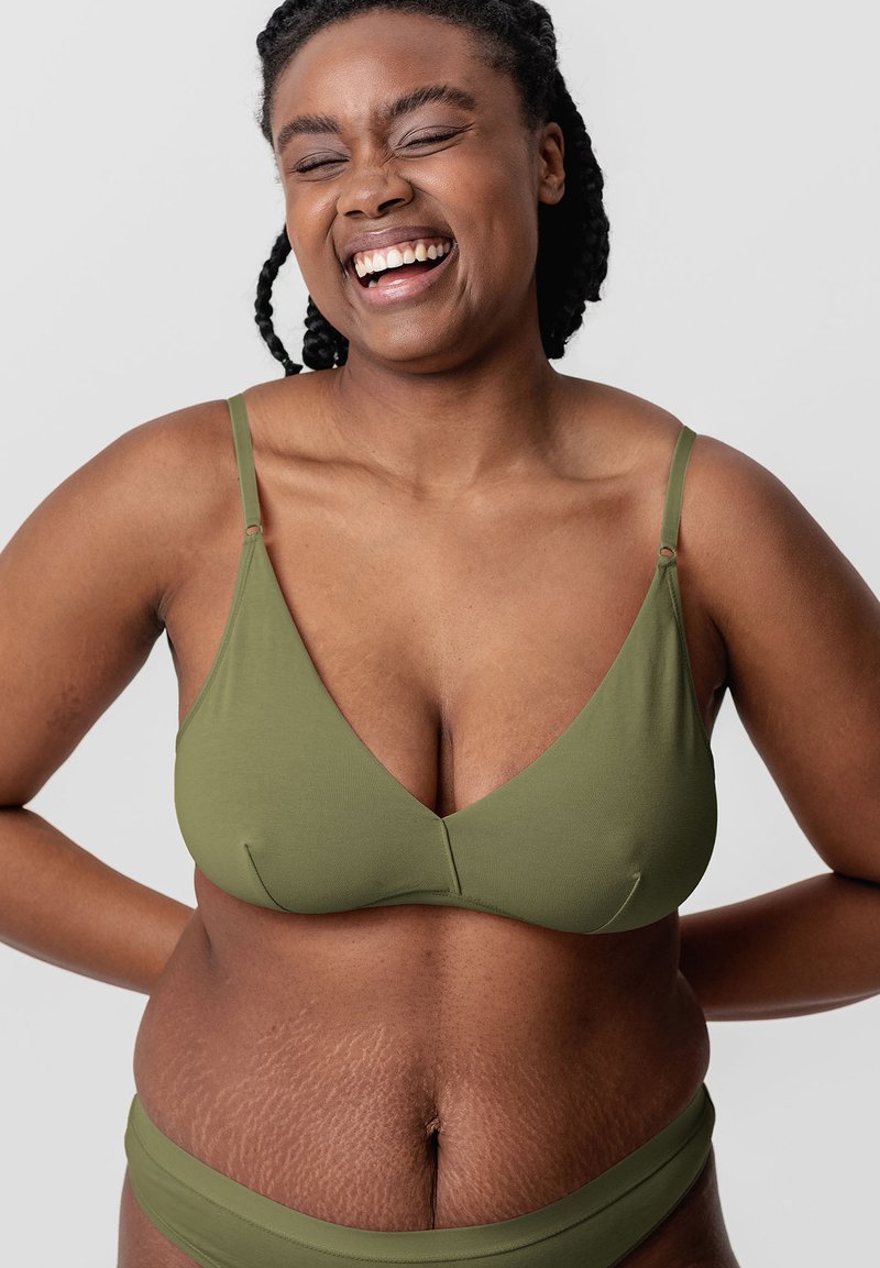 Olive green, seamless bralette with thin adjustable straps and a deep V-neckline. Textured skin visible on midsection.